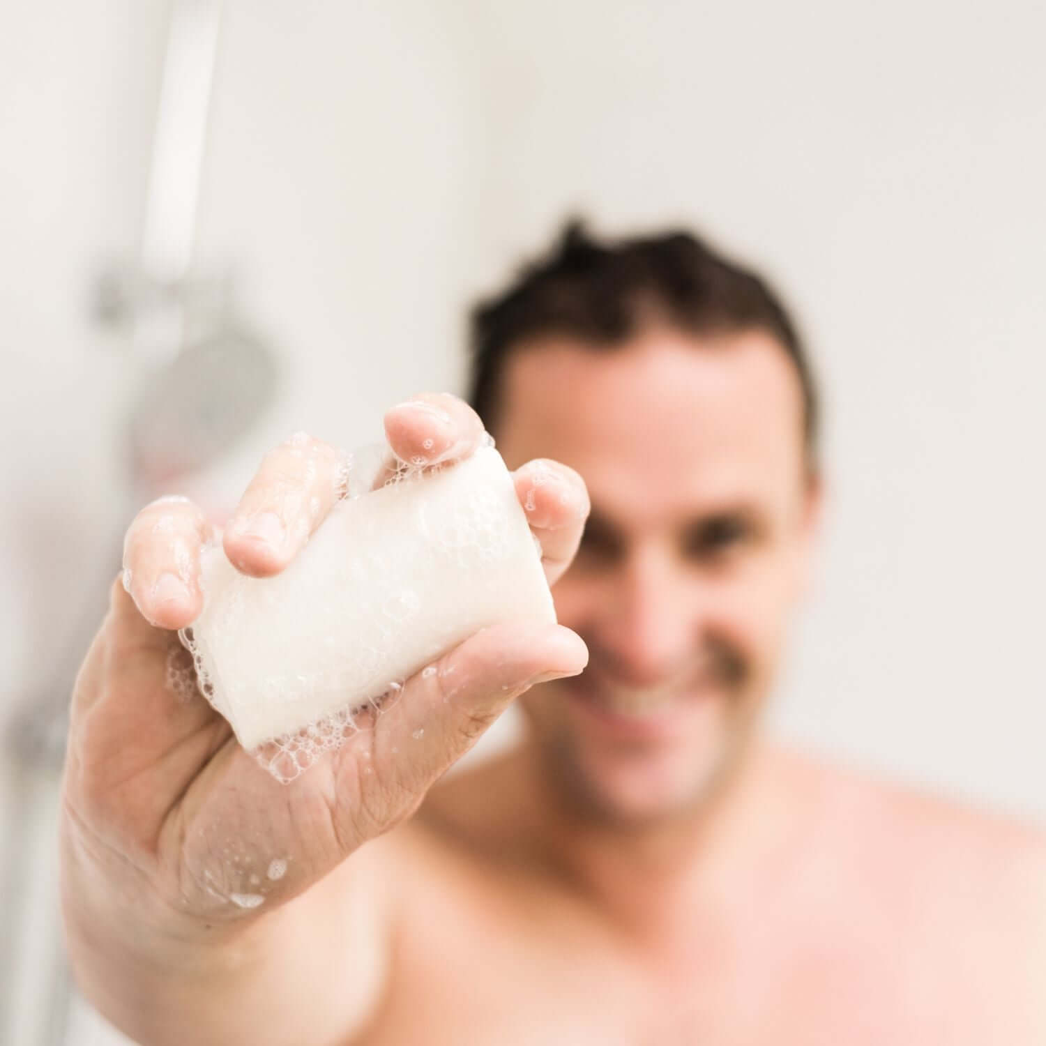 HaarBar Haarseife mit feinem Schaum auf nassen Händen Mann hält eine seife in der hand