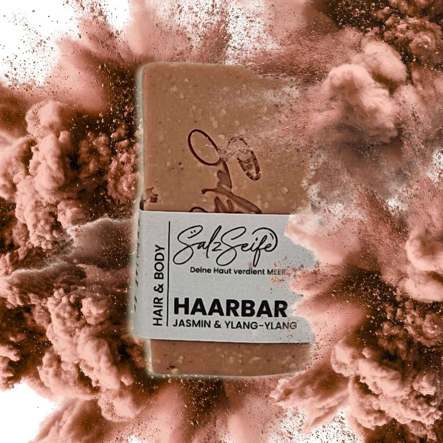 Haarseife HaarBar mit eingeprägtem Salzseife-Logo auf explodierendem Hintergrund auf rosa Tonerde